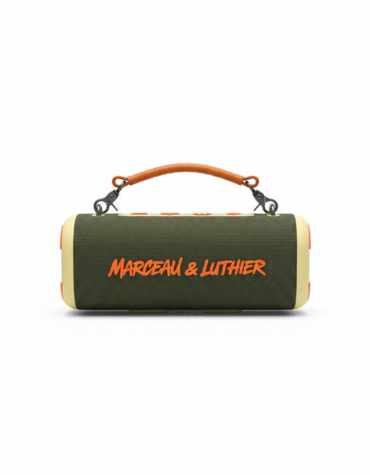 Fotografía de producto del altavoz Bluetooth Nocturne de Marceau & Luthier en color verde oliva con logotipo naranja y asa de cuero, sobre fondo blanco.